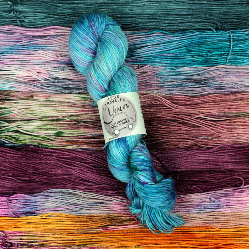 blue skein of yarn on background of several other colors of yarn